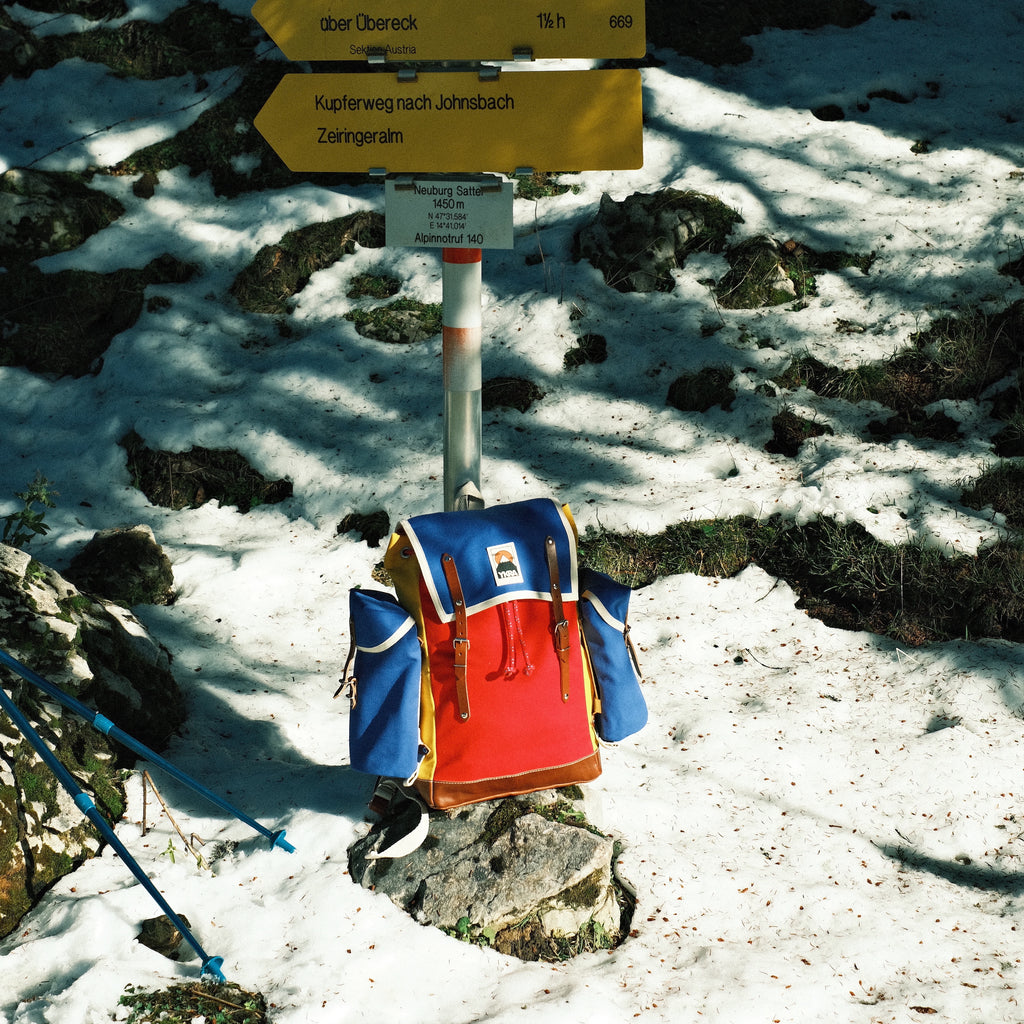 MATRA - BLUE RED YELLOW bellow a yellow trail sign in a snowy forest